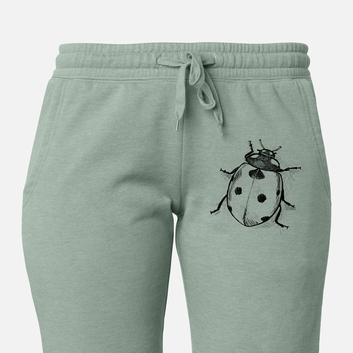 Front of sage green Cali Wave sweatpants, printed with a detailed black ink illustration of a seven-spot ladybird beetle on the leg.