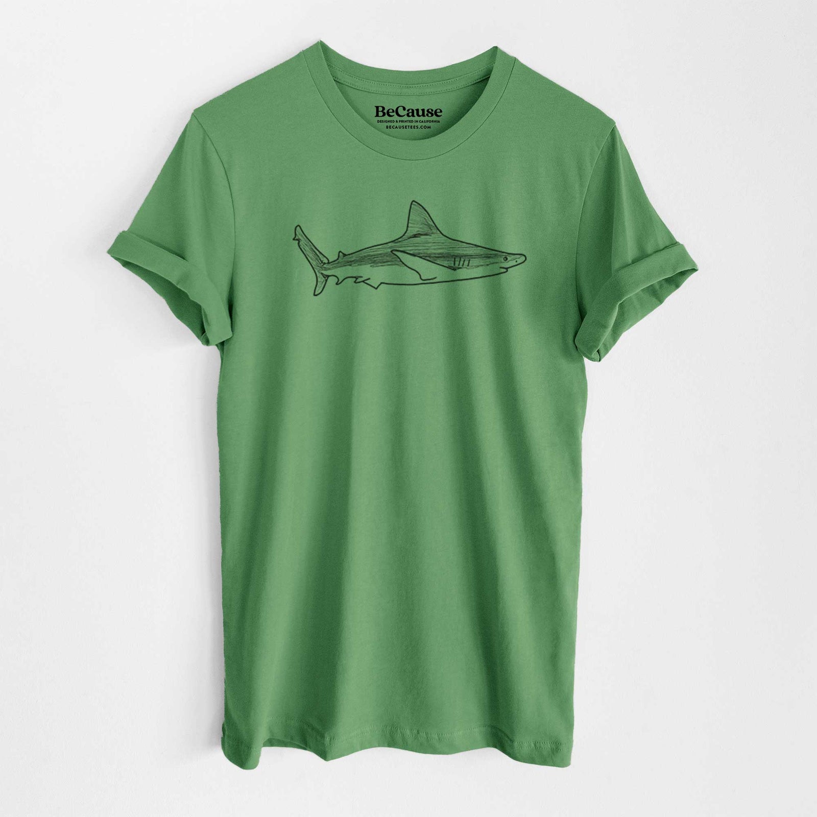 Leaf green lightweight cotton t-shirt laid flat, printed with a black ink illustration of a silvertip shark swimming in profile.