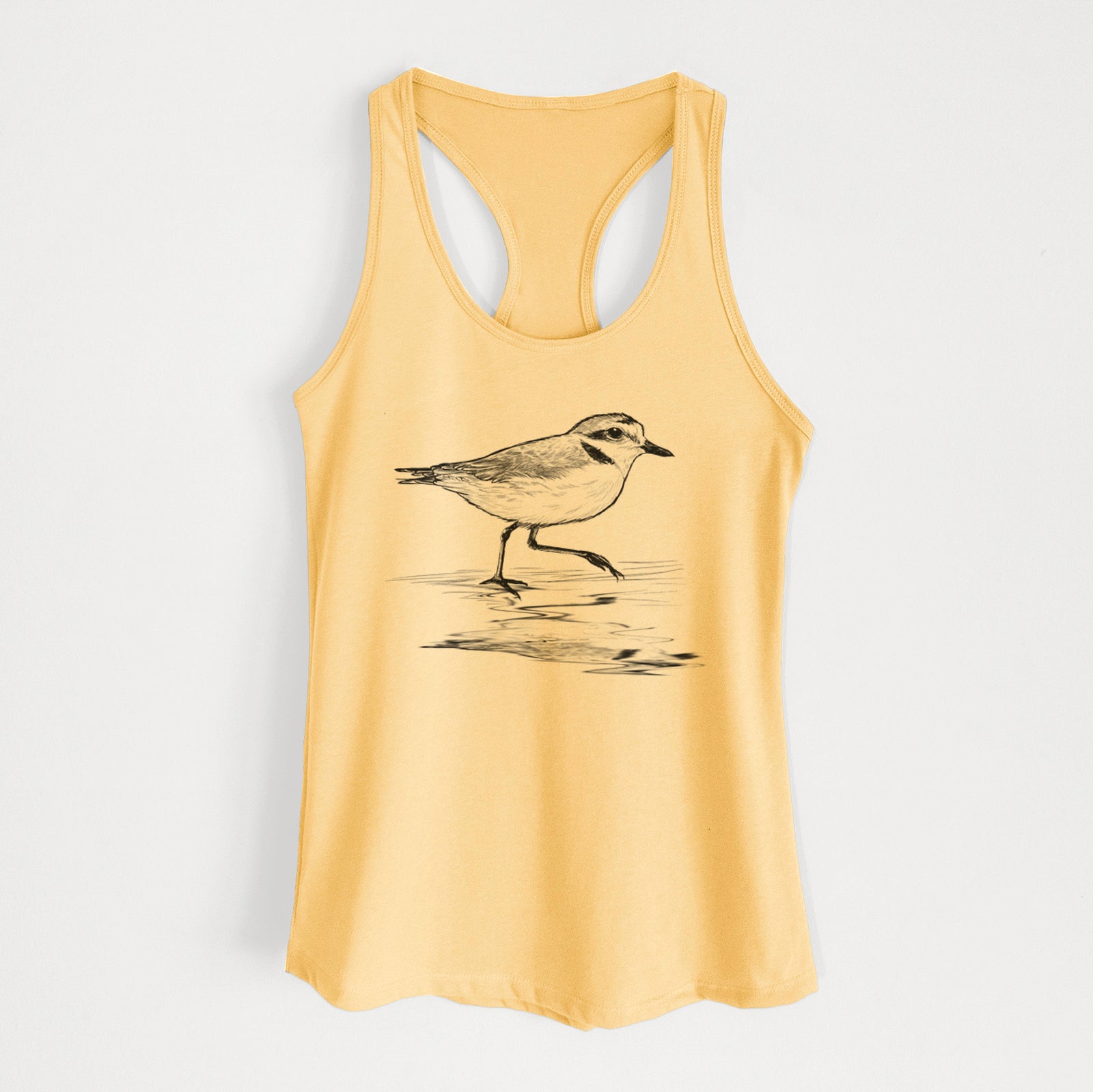 Banana cream women's racerback tank top laid flat, printed with a black ink sketch of a snowy plover running along the wet shoreline.