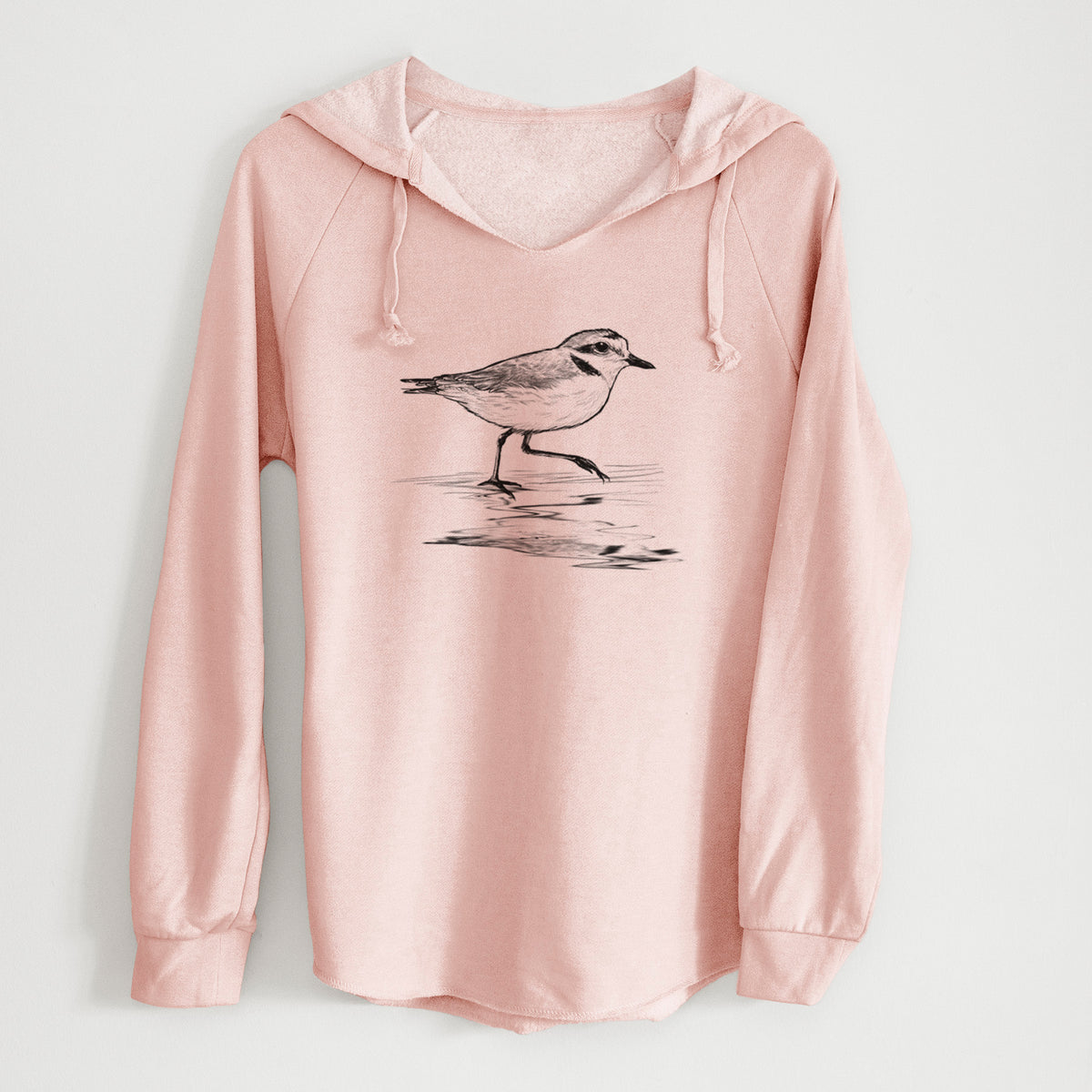 Blush pink women's Cali Wave hooded sweatshirt laid flat, printed with a black ink sketch of a snowy plover running along the wet shoreline.