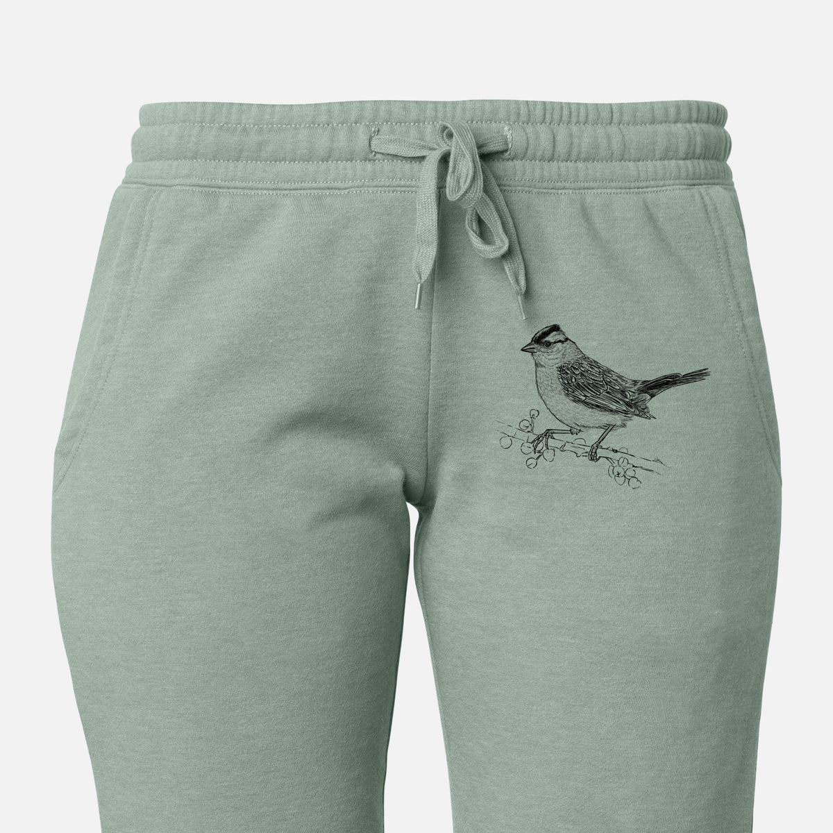 Front of sage green Cali Wave sweatpants, printed with a detailed black ink sketch of a white-crowned sparrow perched on a branch on the leg.
