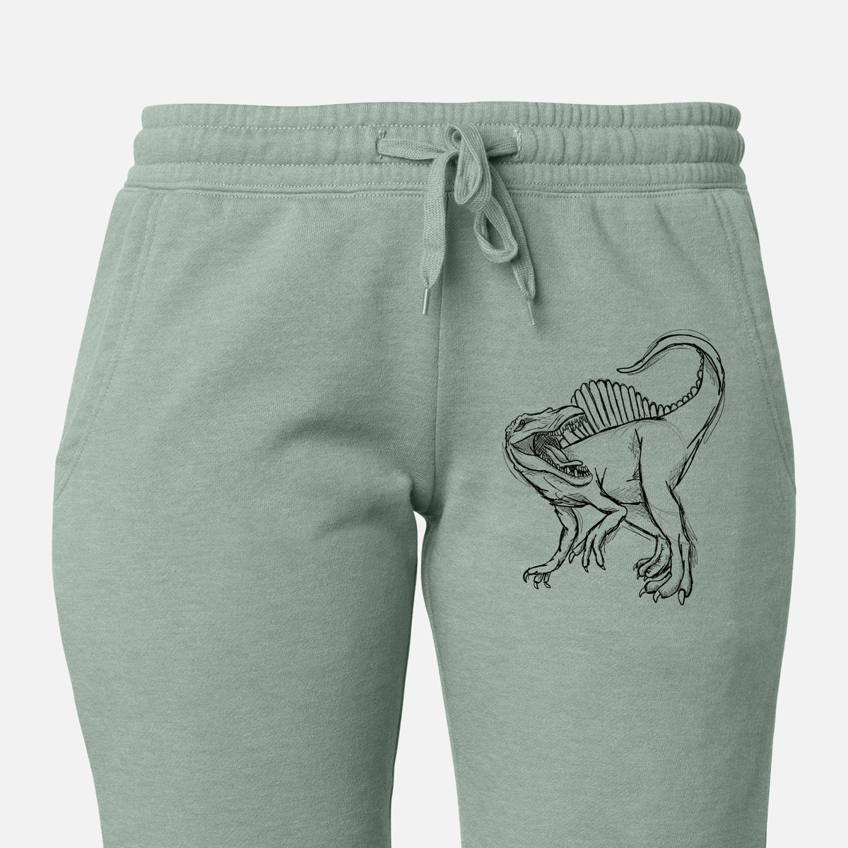 Front of sage green Cali Wave sweatpants, printed with a black ink illustration of a Spinosaurus with its tall sail-shaped back on the leg.