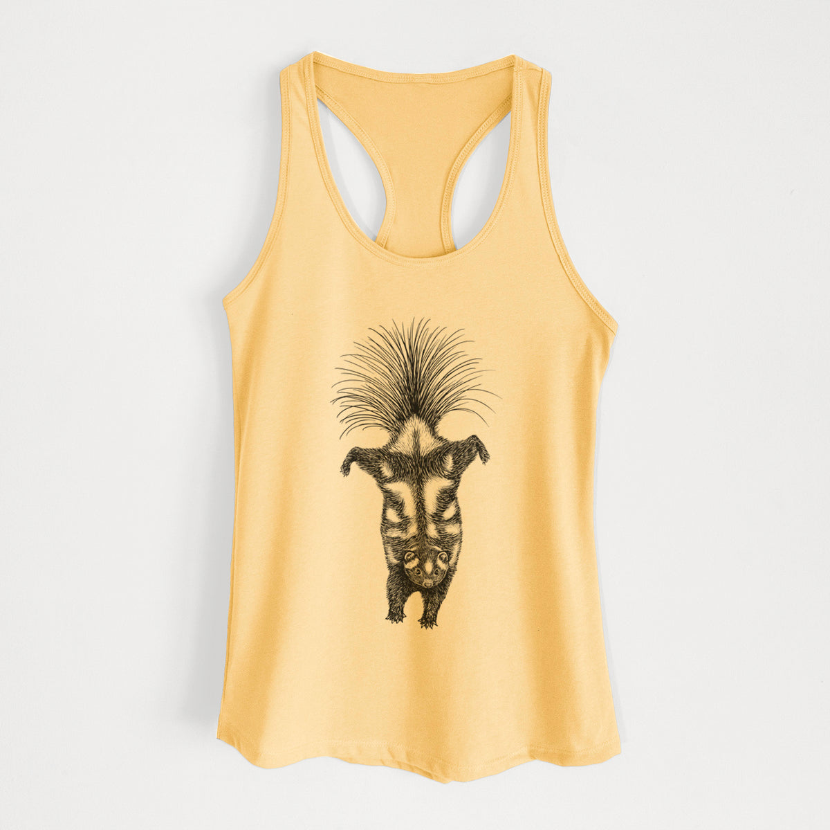 Banana cream women's racerback tank top laid flat, printed with a black ink illustration of a spotted skunk doing a handstand with its tail fanned.