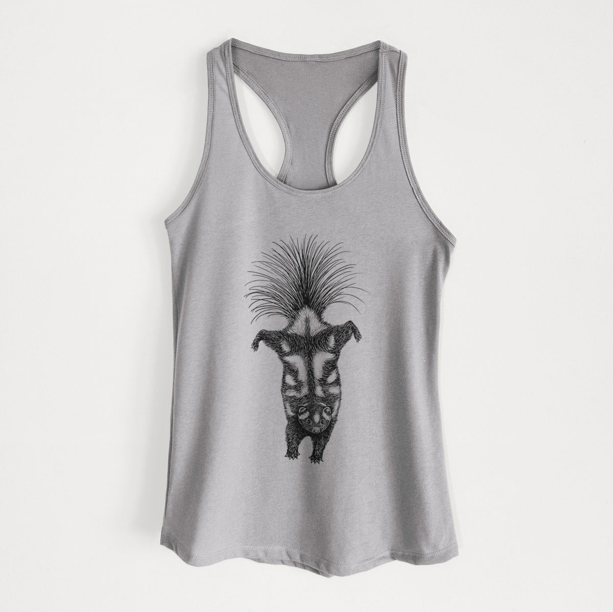 Heather grey women's racerback tank top laid flat, printed with a black ink illustration of a spotted skunk doing a handstand with its tail fanned.