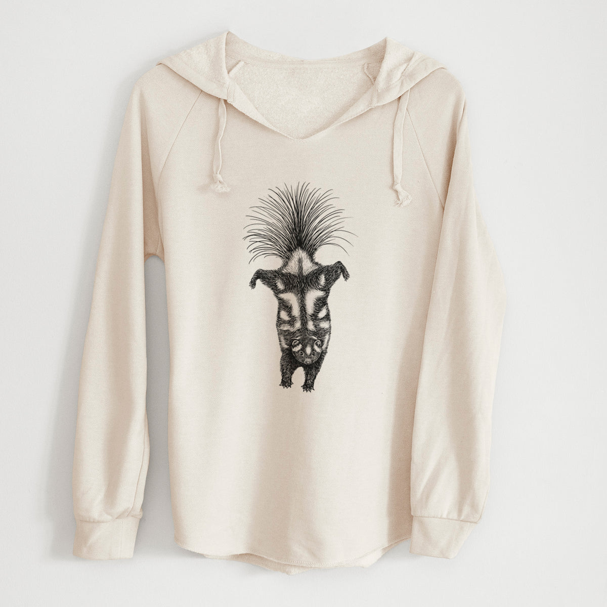 Bone cream women's Cali Wave hooded sweatshirt laid flat, printed with a black ink illustration of a spotted skunk doing a handstand with its tail fanned.