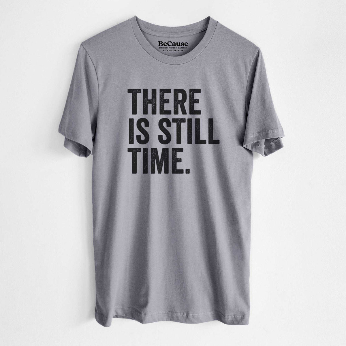 Storm grey lightweight cotton t-shirt laid flat, printed with bold black words reading There Is Still Time.