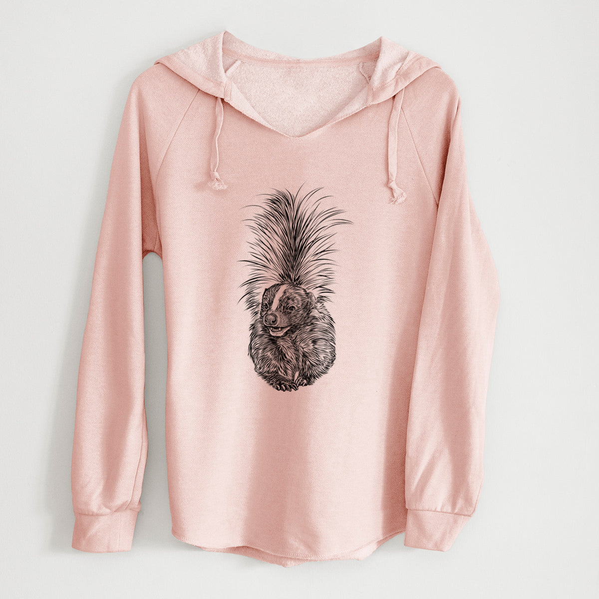 Blush pink women's Cali Wave hooded sweatshirt laid flat, printed with a detailed black ink illustration of a striped skunk with its tail raised.