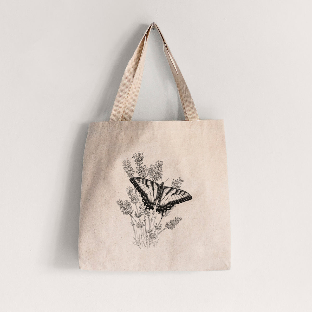 Natural canvas tote bag printed with a black ink illustration of a swallowtail butterfly resting on lavender.