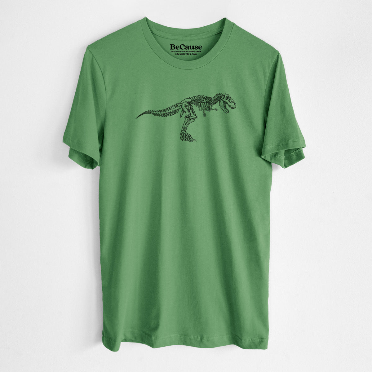 Leaf green lightweight cotton t-shirt laid flat, printed with a black ink illustration of a Tyrannosaurus rex skeleton.