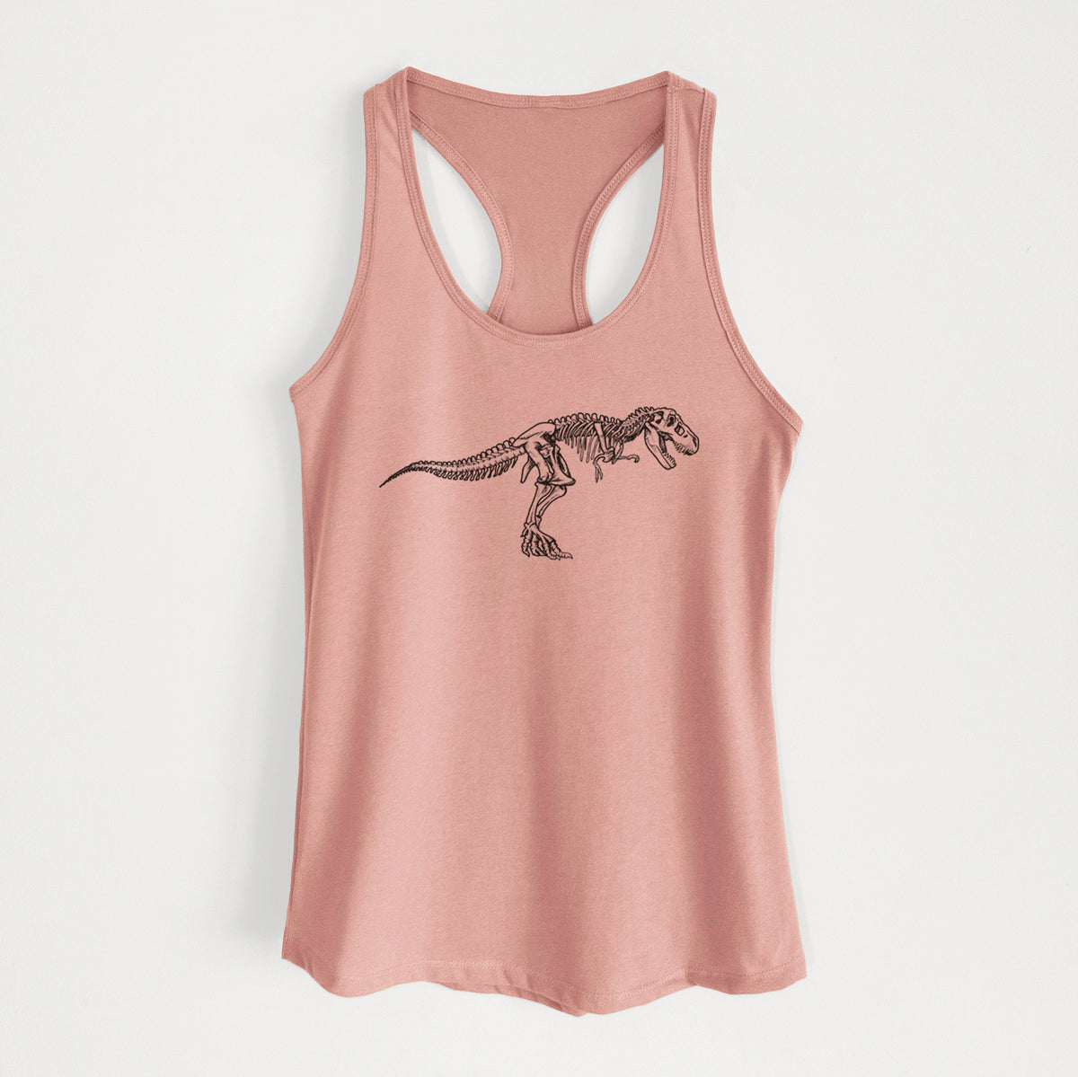 Desert pink women's racerback tank top laid flat, printed with a black ink illustration of a Tyrannosaurus rex skeleton.