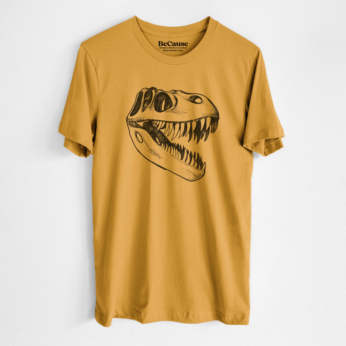 Mustard yellow lightweight cotton t-shirt laid flat, printed with a black ink illustration of a Tyrannosaurus rex skull with sharp teeth.
