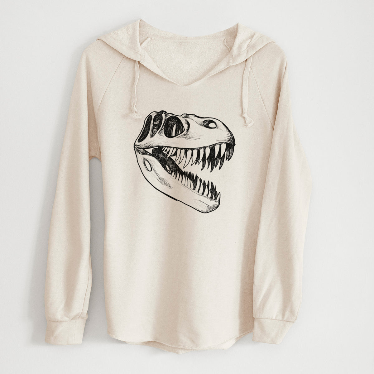 Bone cream women's Cali Wave hooded sweatshirt laid flat, printed with a black ink illustration of a Tyrannosaurus rex skull with sharp teeth.