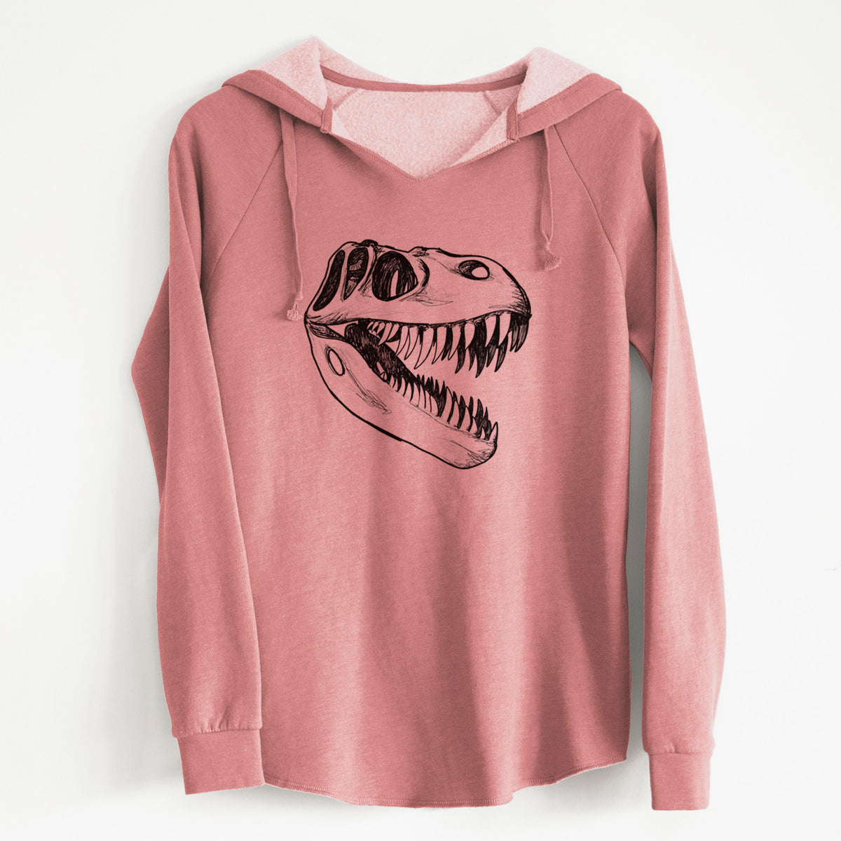 Dusty rose women's Cali Wave hooded sweatshirt laid flat, printed with a black ink illustration of a Tyrannosaurus rex skull with sharp teeth.