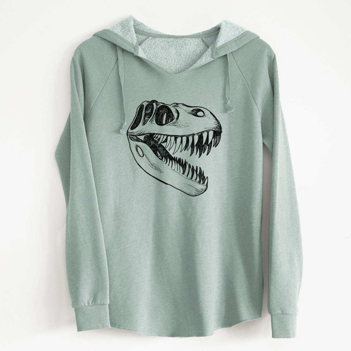 Sage green women's Cali Wave hooded sweatshirt laid flat, printed with a black ink illustration of a Tyrannosaurus rex skull with sharp teeth.
