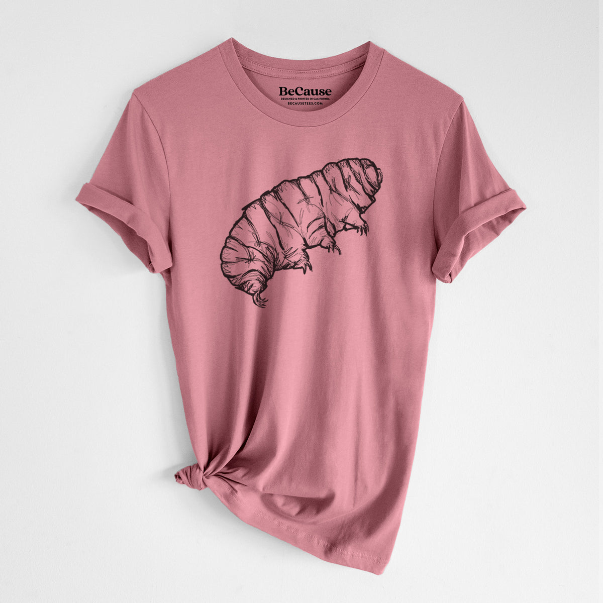 Mauve pink lightweight cotton t-shirt laid flat with the sleeves rolled, printed with a detailed black ink illustration of a tardigrade, or water bear.
