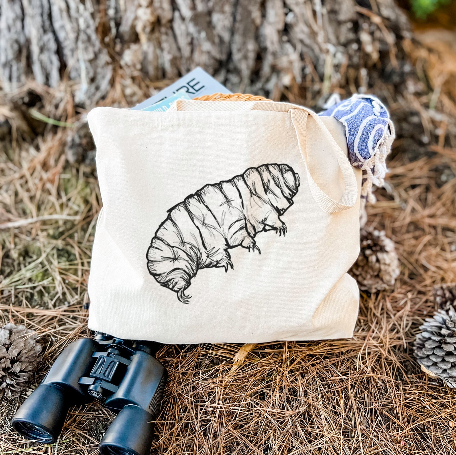Natural canvas tote bag printed with a detailed black ink illustration of a tardigrade, or water bear.
