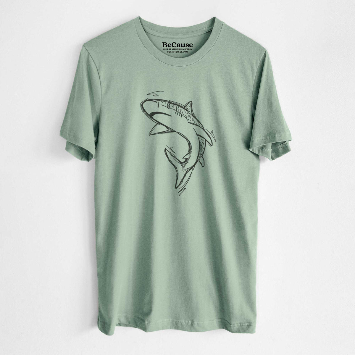 Sage green lightweight cotton t-shirt laid flat, printed with a black ink illustration of a tiger shark swimming in a curve.