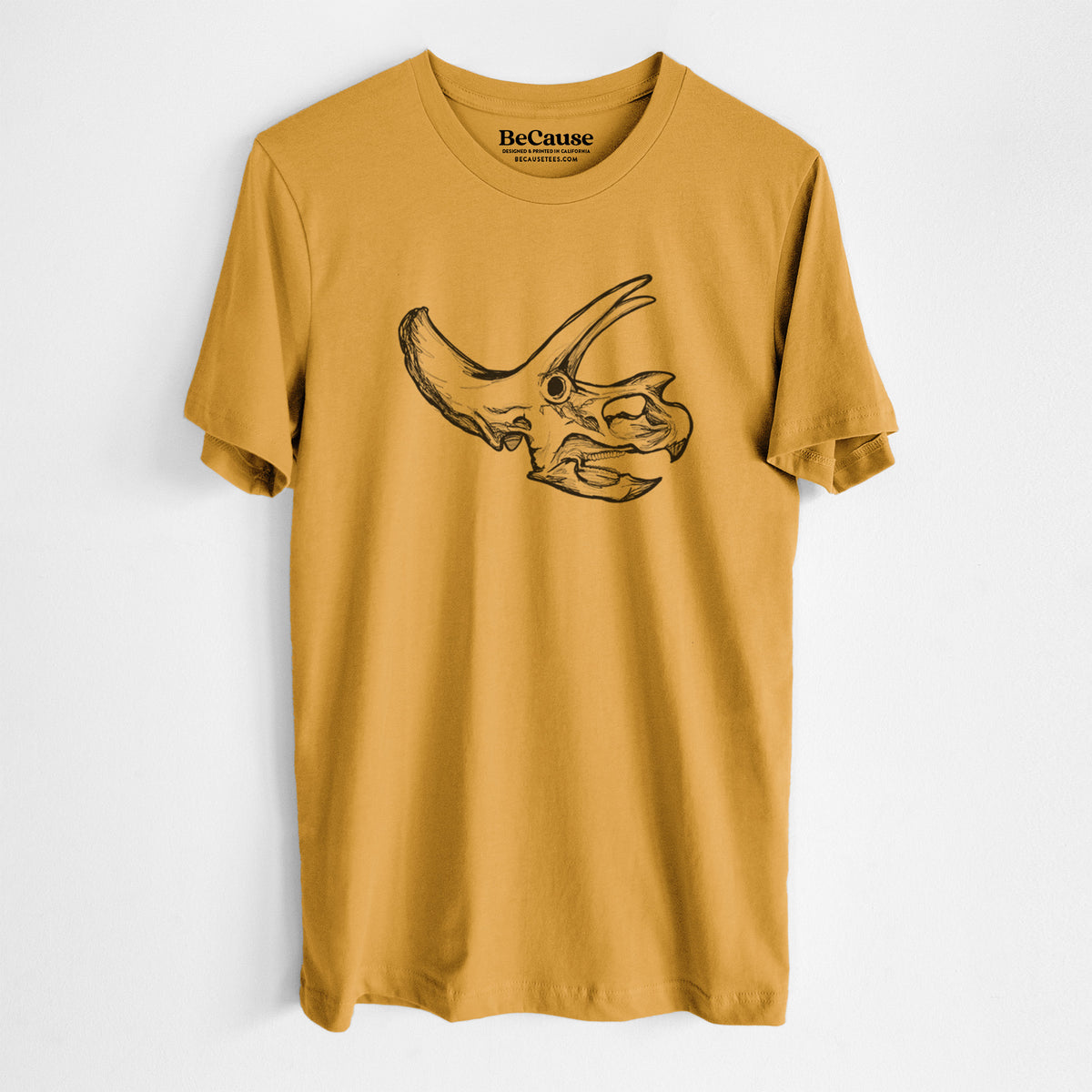 Mustard yellow lightweight cotton t-shirt laid flat, printed with a detailed black ink illustration of a Triceratops skull with its horns and frill.