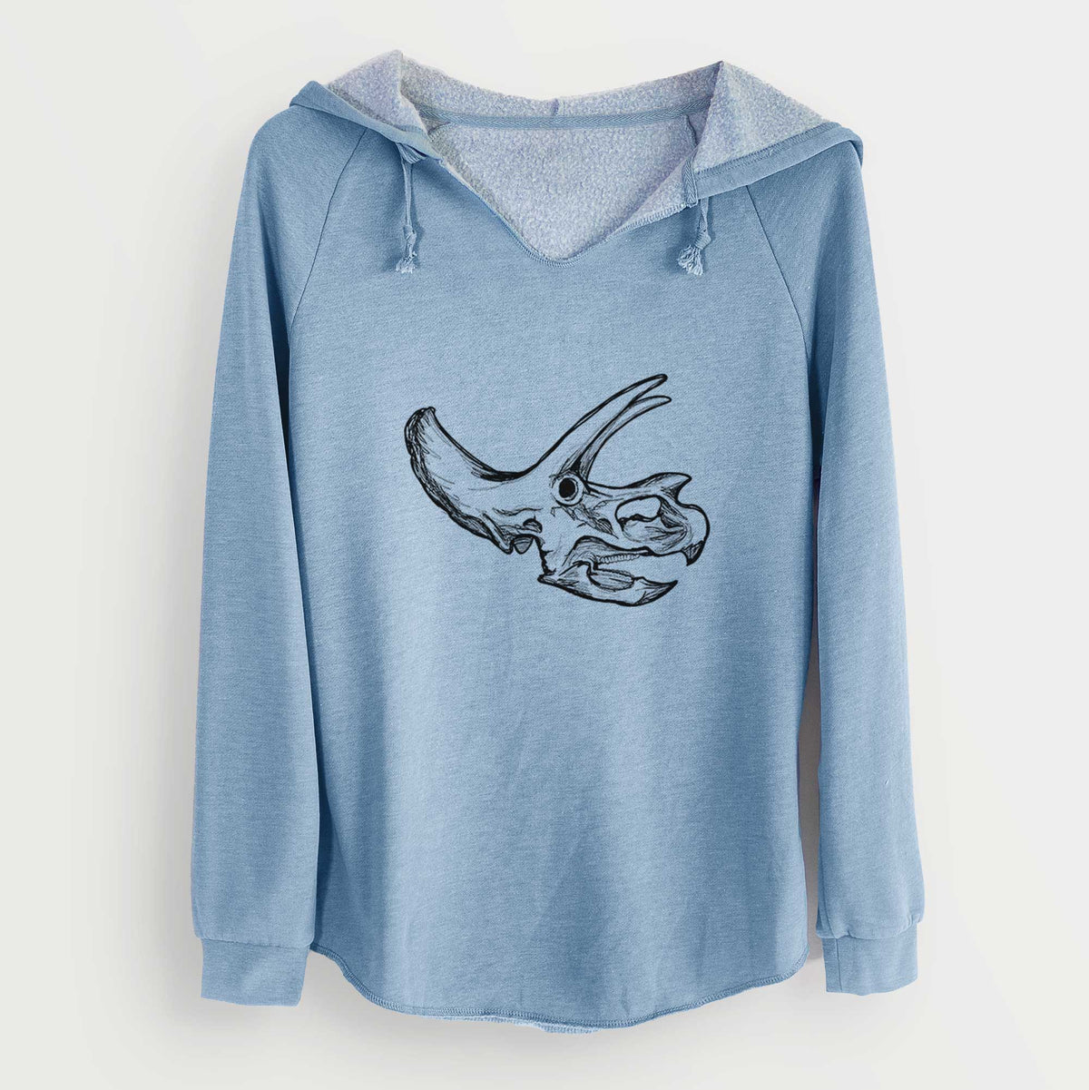 Misty blue women's Cali Wave hooded sweatshirt laid flat, printed with a detailed black ink illustration of a Triceratops skull with its horns and frill.