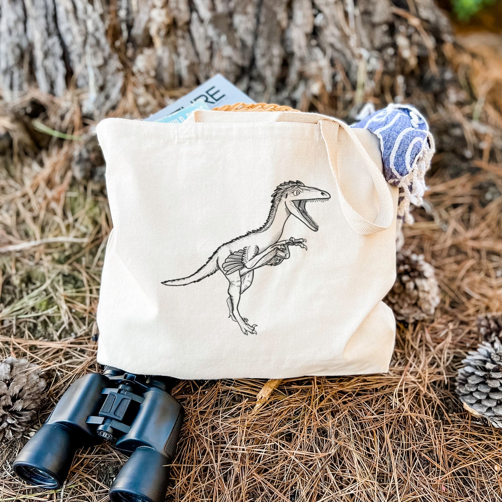 Natural canvas tote bag printed with a black ink illustration of a Troodon dinosaur running.