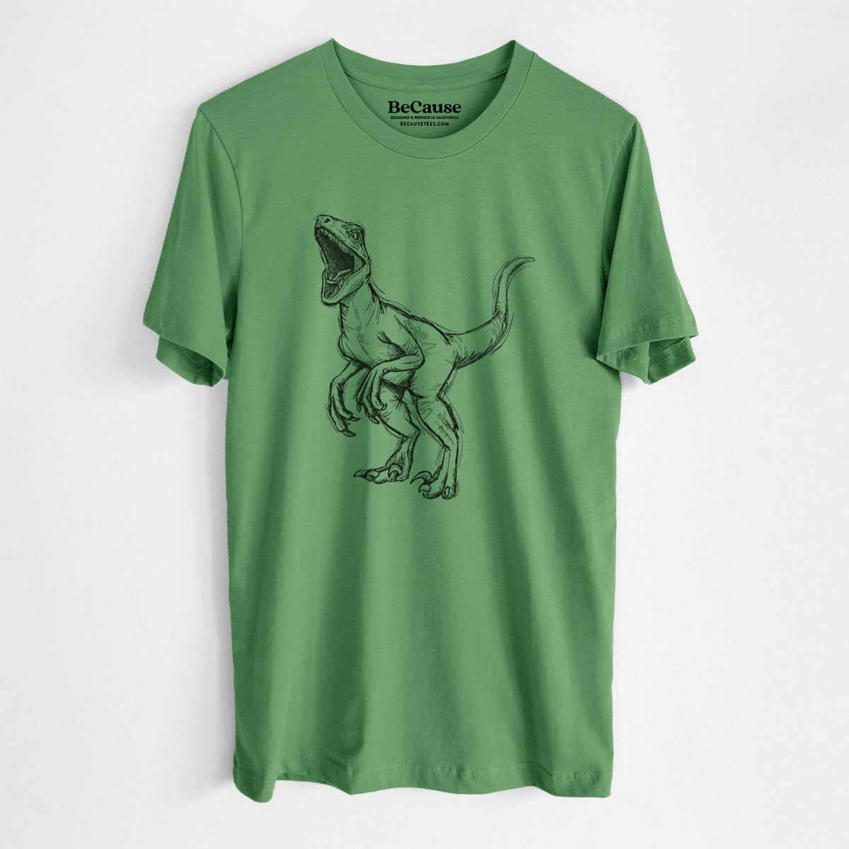 Leaf green lightweight cotton t-shirt laid flat, printed with a black ink illustration of a Velociraptor roaring.