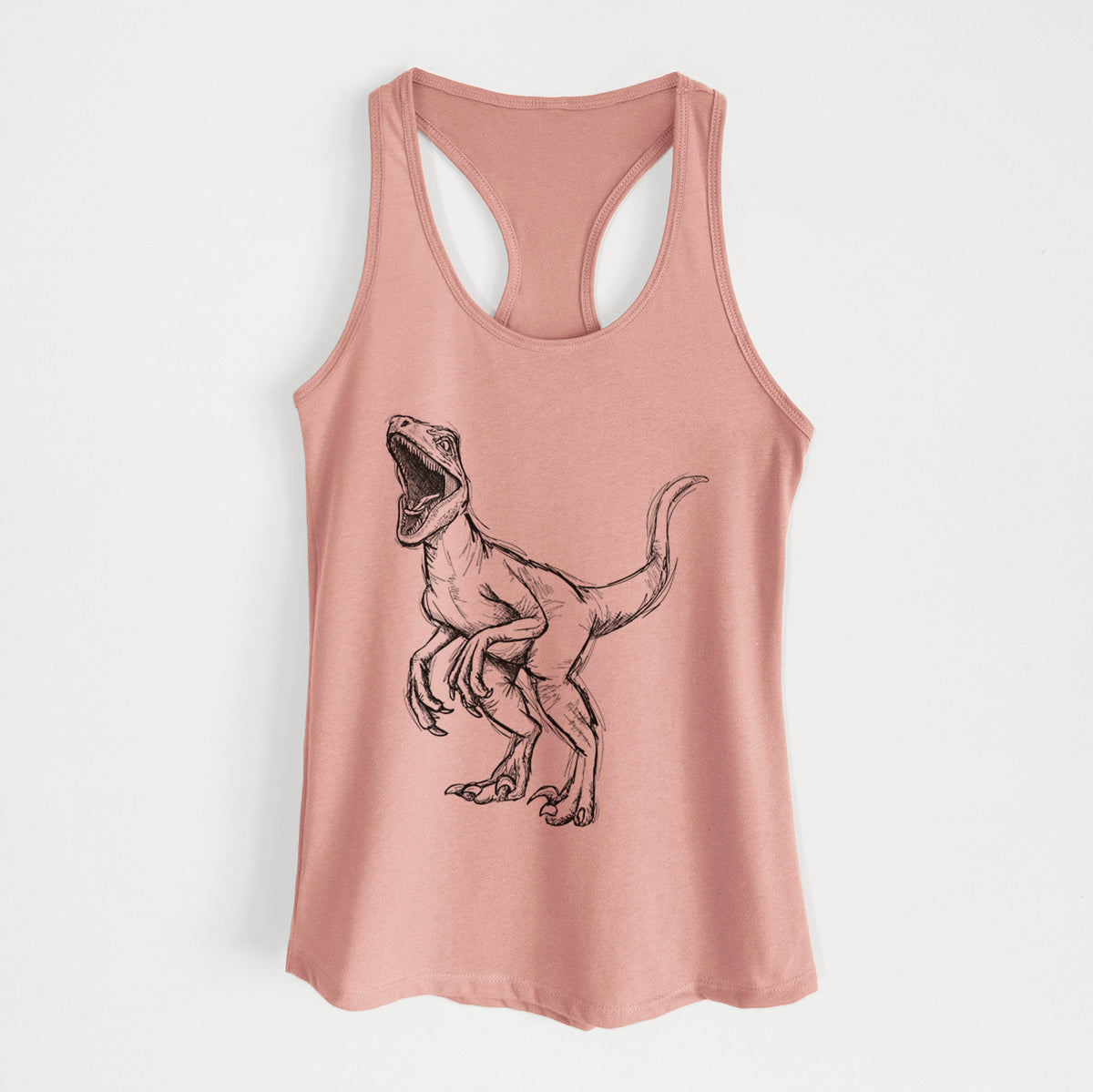 Desert pink women's racerback tank top laid flat, printed with a black ink illustration of a Velociraptor roaring.