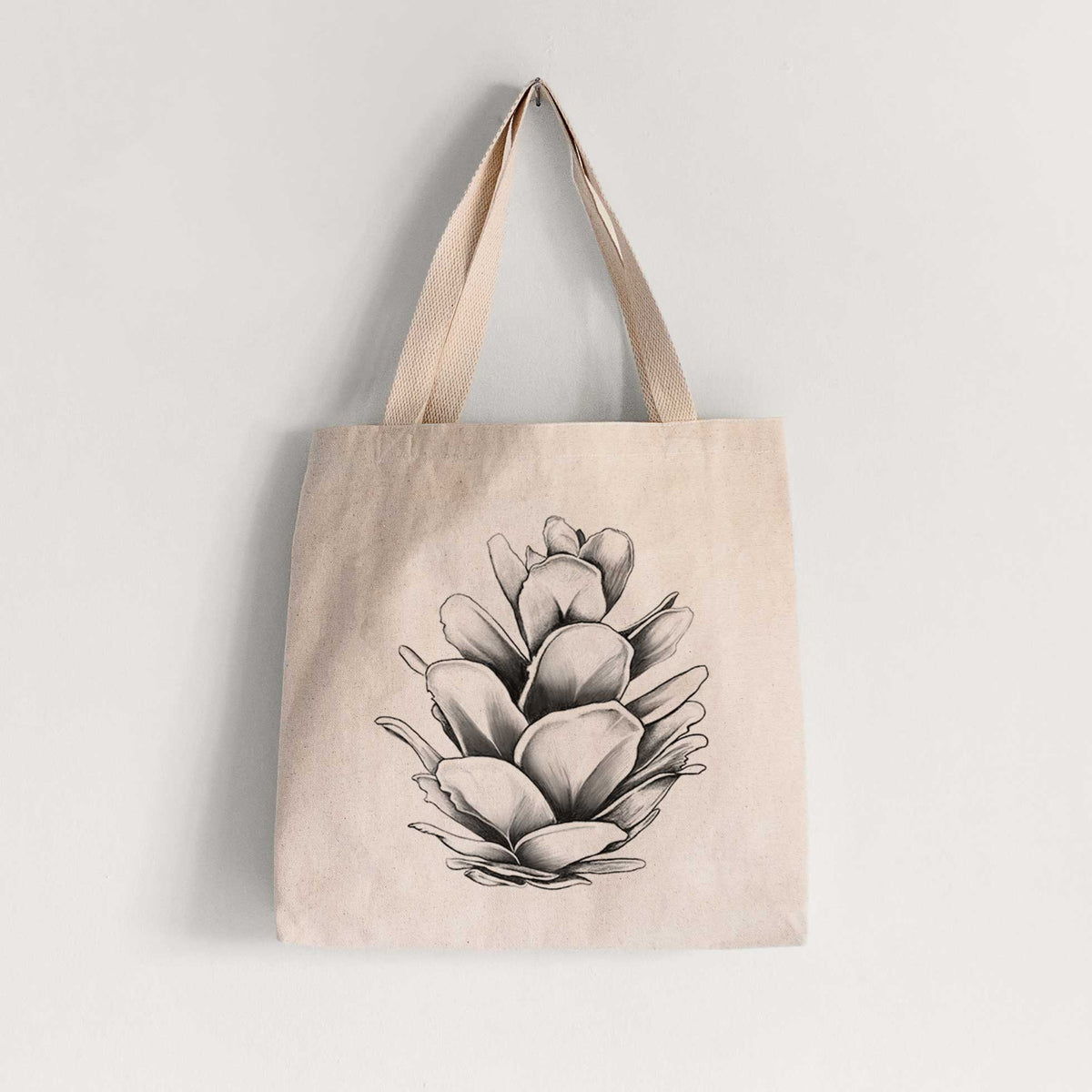 Natural canvas tote bag printed with a detailed black ink illustration of a western hemlock pine cone.