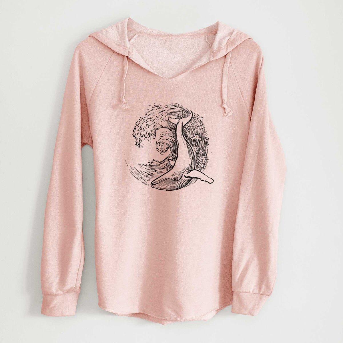 Blush pink women's Cali Wave hooded sweatshirt laid flat, printed with a black ink illustration of a humpback whale swimming inside a curling ocean wave.