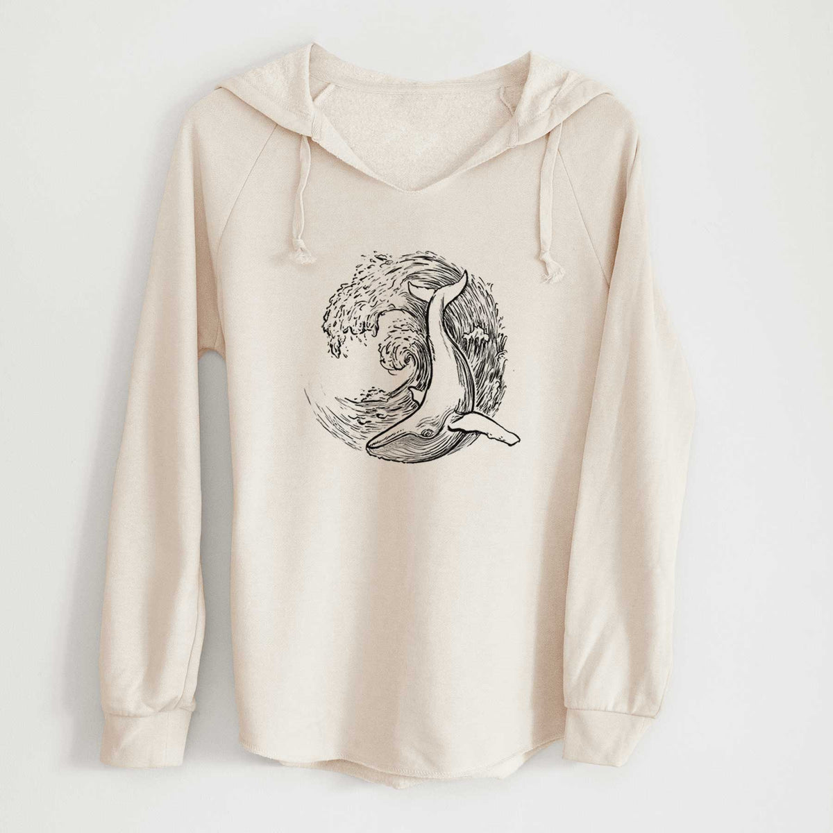 Bone cream women's Cali Wave hooded sweatshirt laid flat, printed with a black ink illustration of a humpback whale swimming inside a curling ocean wave.