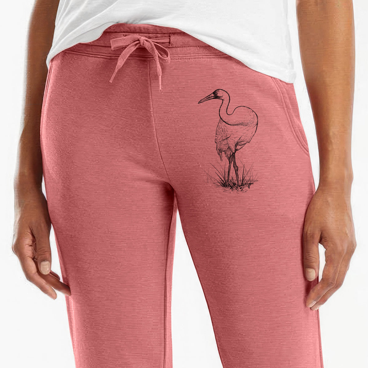 Front of dusty rose Cali Wave sweatpants, printed with a detailed black ink illustration of a whooping crane standing in grass on the leg.