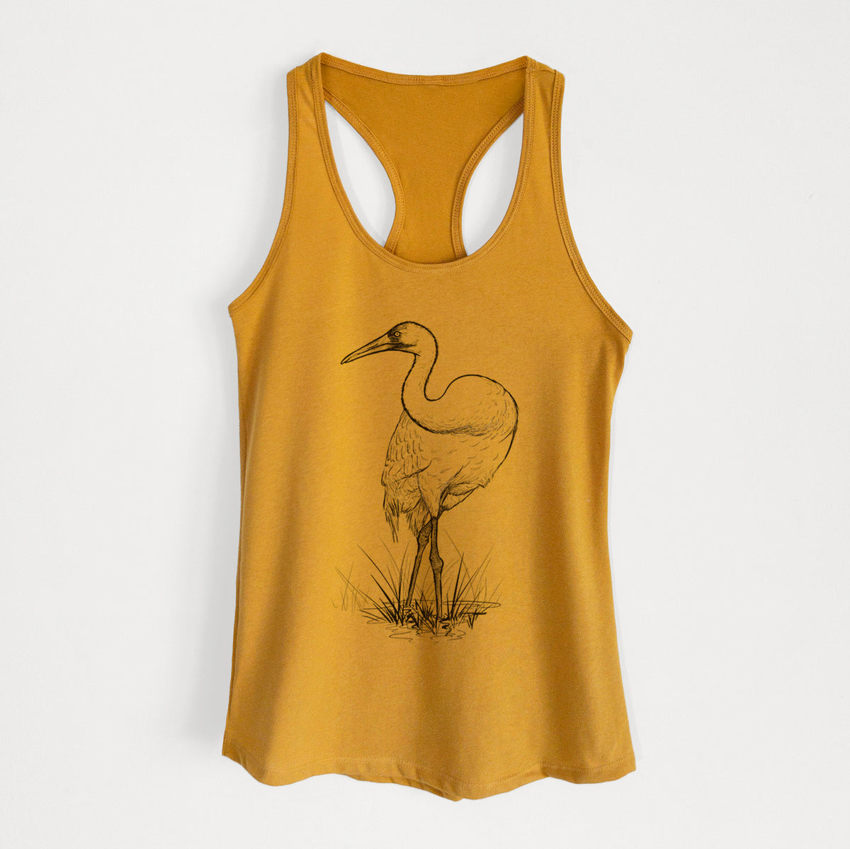 Gold women's racerback tank top laid flat, printed with a detailed black ink illustration of a whooping crane standing in grass.