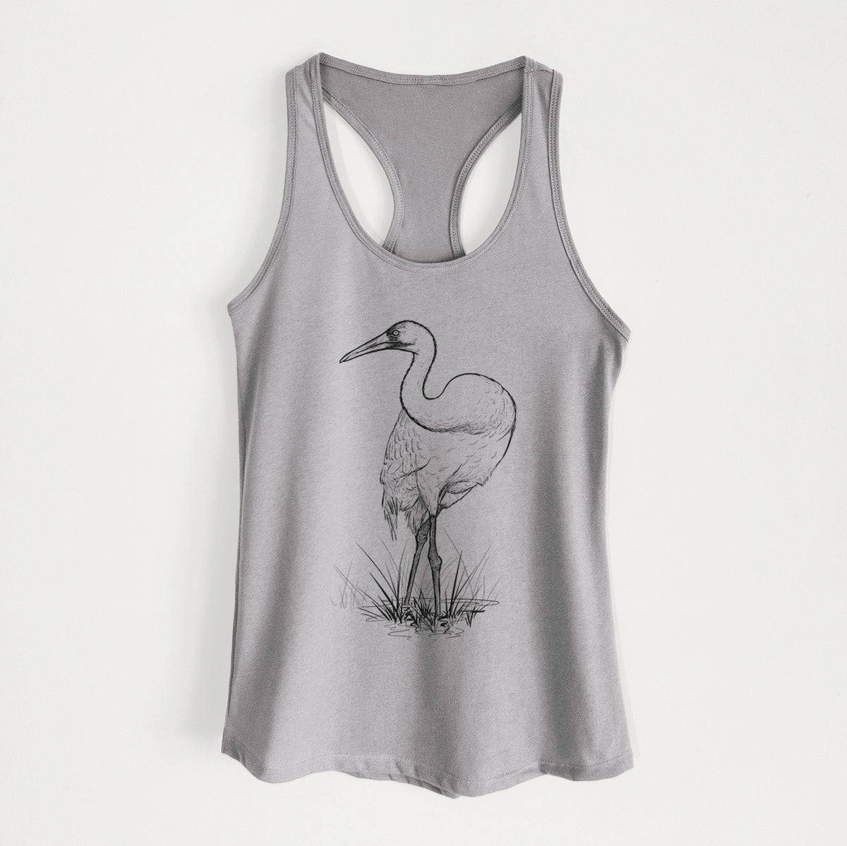 Heather grey women's racerback tank top laid flat, printed with a detailed black ink illustration of a whooping crane standing in grass.