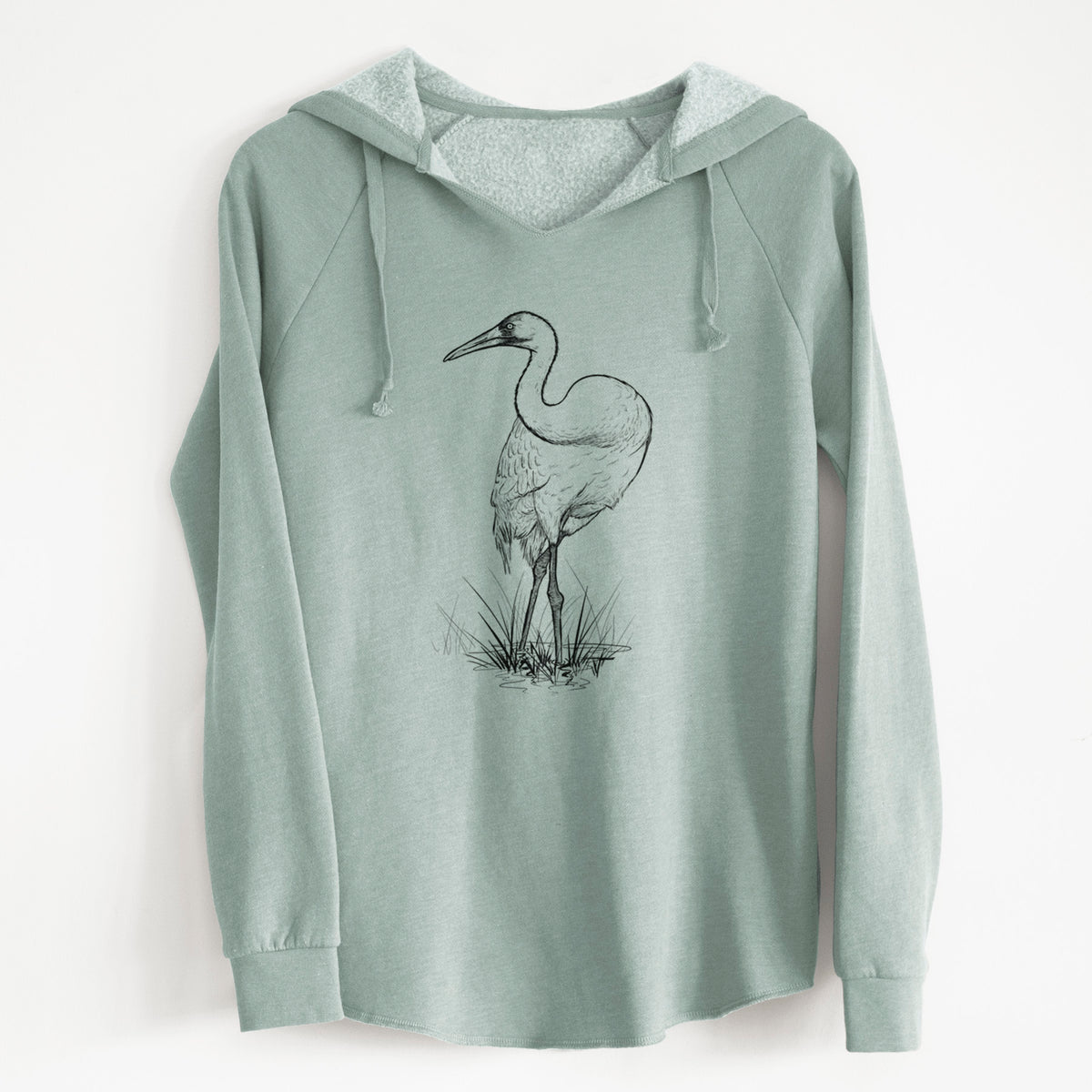 Sage green women's Cali Wave hooded sweatshirt laid flat, printed with a detailed black ink illustration of a whooping crane standing in grass.