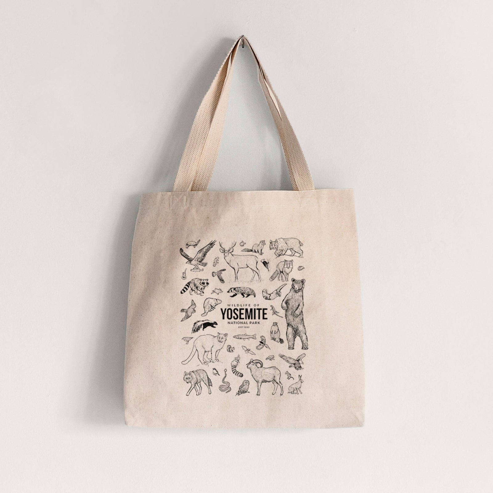 Natural canvas tote bag printed with a collection of black ink wildlife illustrations surrounding the words Yosemite National Park.