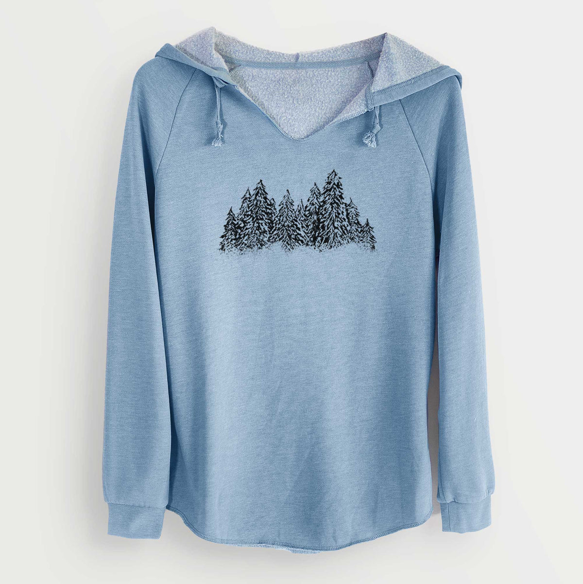 Misty blue women's Cali Wave hooded sweatshirt laid flat, printed with a black ink illustration of a row of snow-dusted evergreen trees.