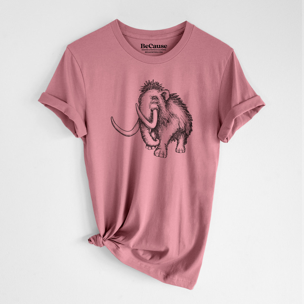Mauve pink lightweight cotton t-shirt laid flat with the sleeves rolled, printed with a black ink illustration of a woolly mammoth with long curved tusks.