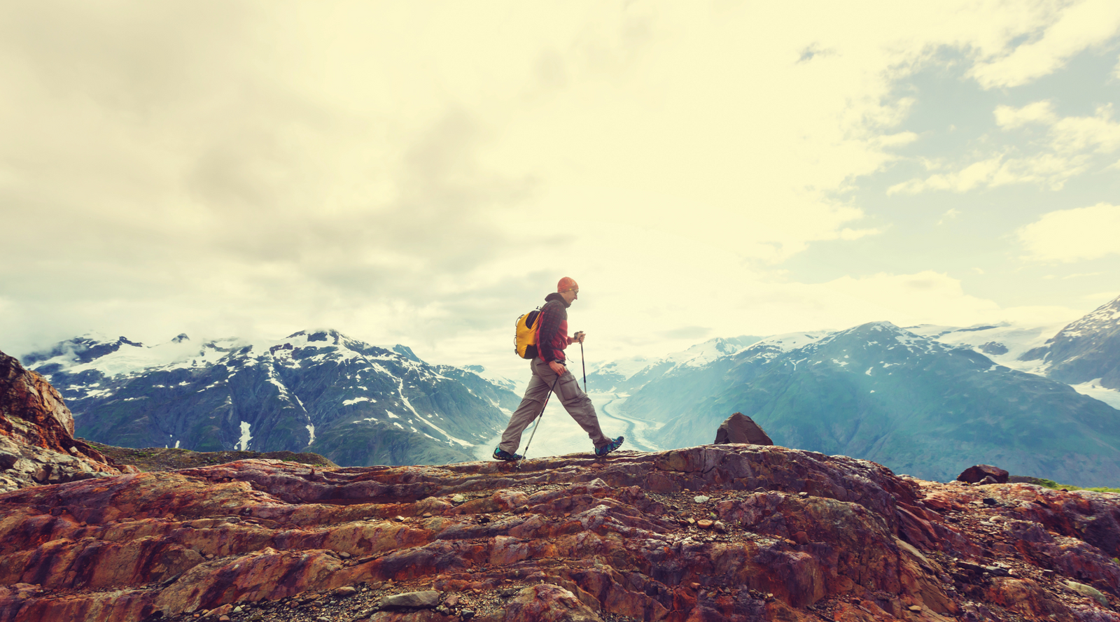 Person hiking on a ridge with mountains in the background, gift guide for hikers