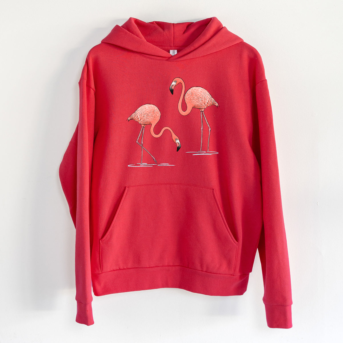 American Flamingos - Phoenicopterus ruber - Statement Midweight Hoodie in Cherry Red, hanging on a white wall, with a front kangaroo pocket and no drawcords.