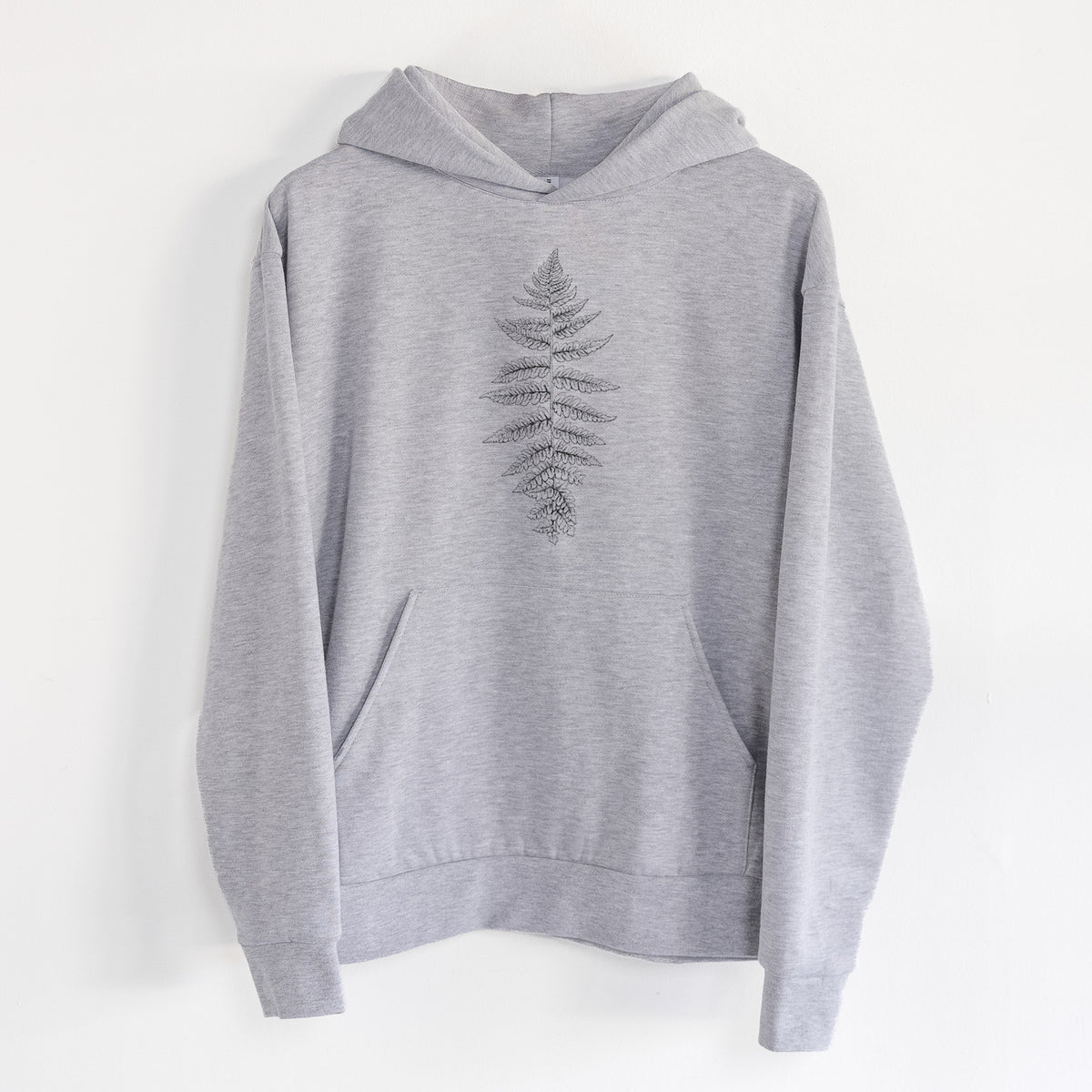 Athyrium filix femina - Lady Fern - Statement Midweight Hoodie in Heather Grey, hanging on a white wall, with a front kangaroo pocket and no drawcords.