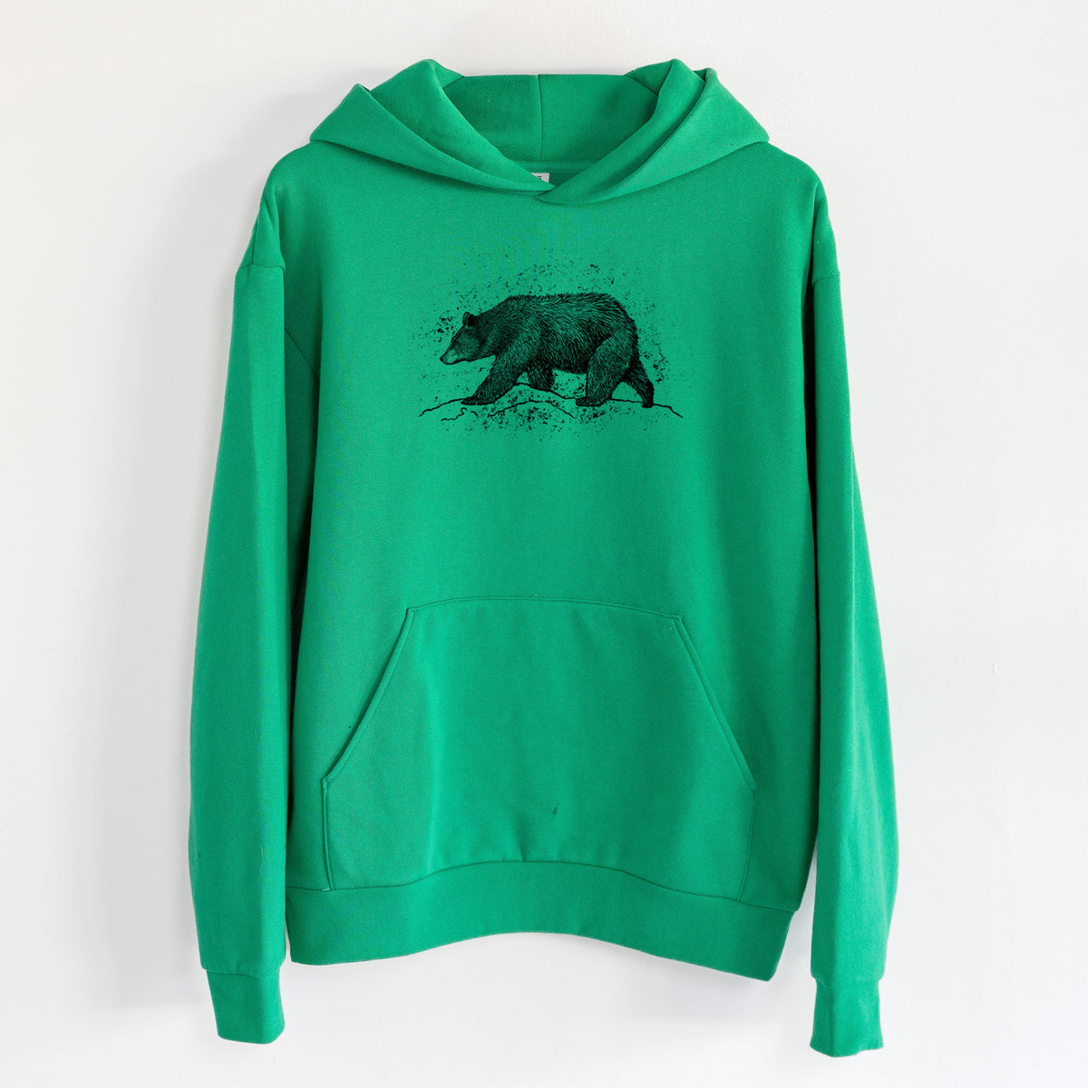 Black Bear - Statement Midweight Hoodie in Kelly Green, hanging on a white wall, with a front kangaroo pocket and no drawcords.