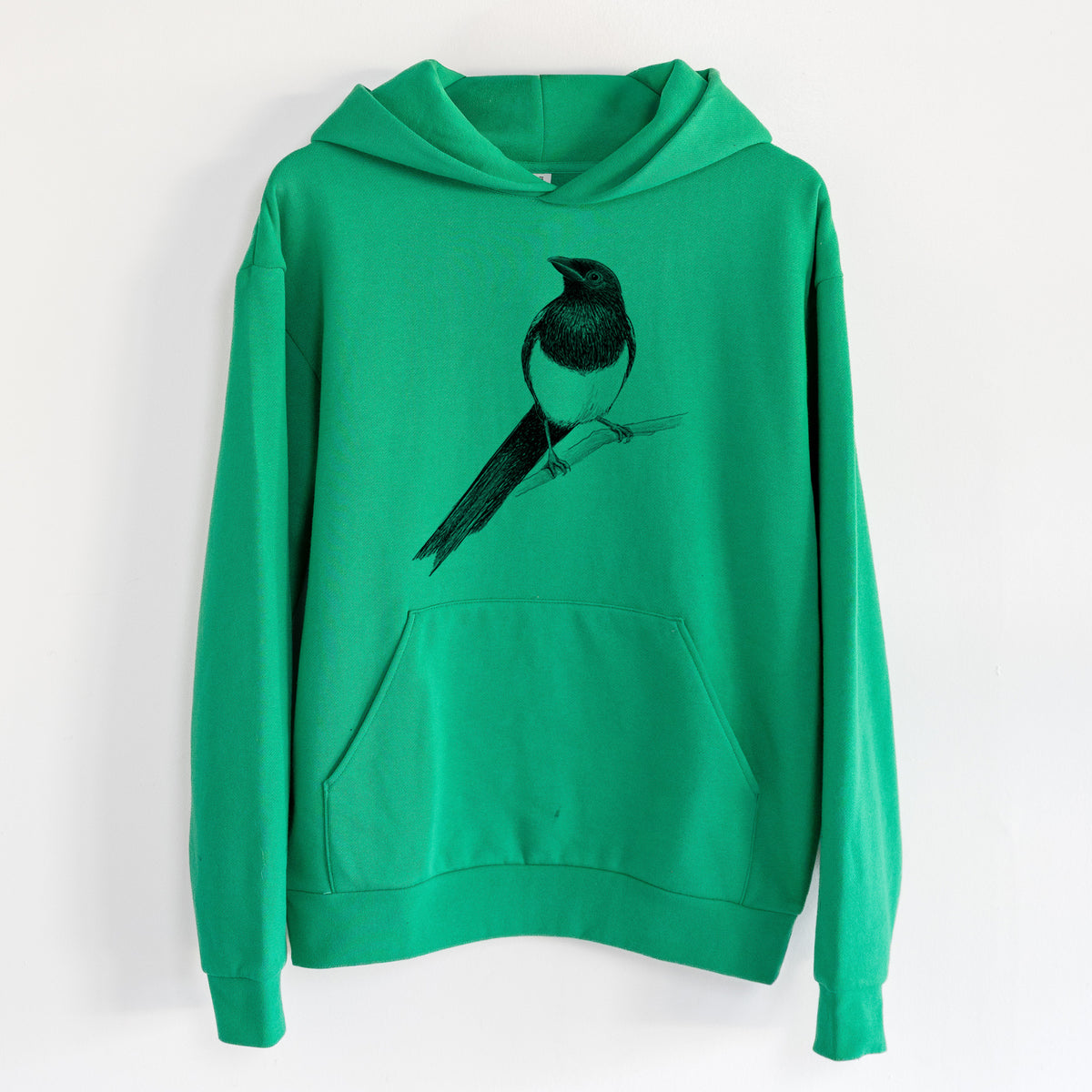 Black-billed Magpie - Pica hudsonia - Statement Midweight Hoodie in Kelly Green, hanging on a white wall, with a front kangaroo pocket and no drawcords.
