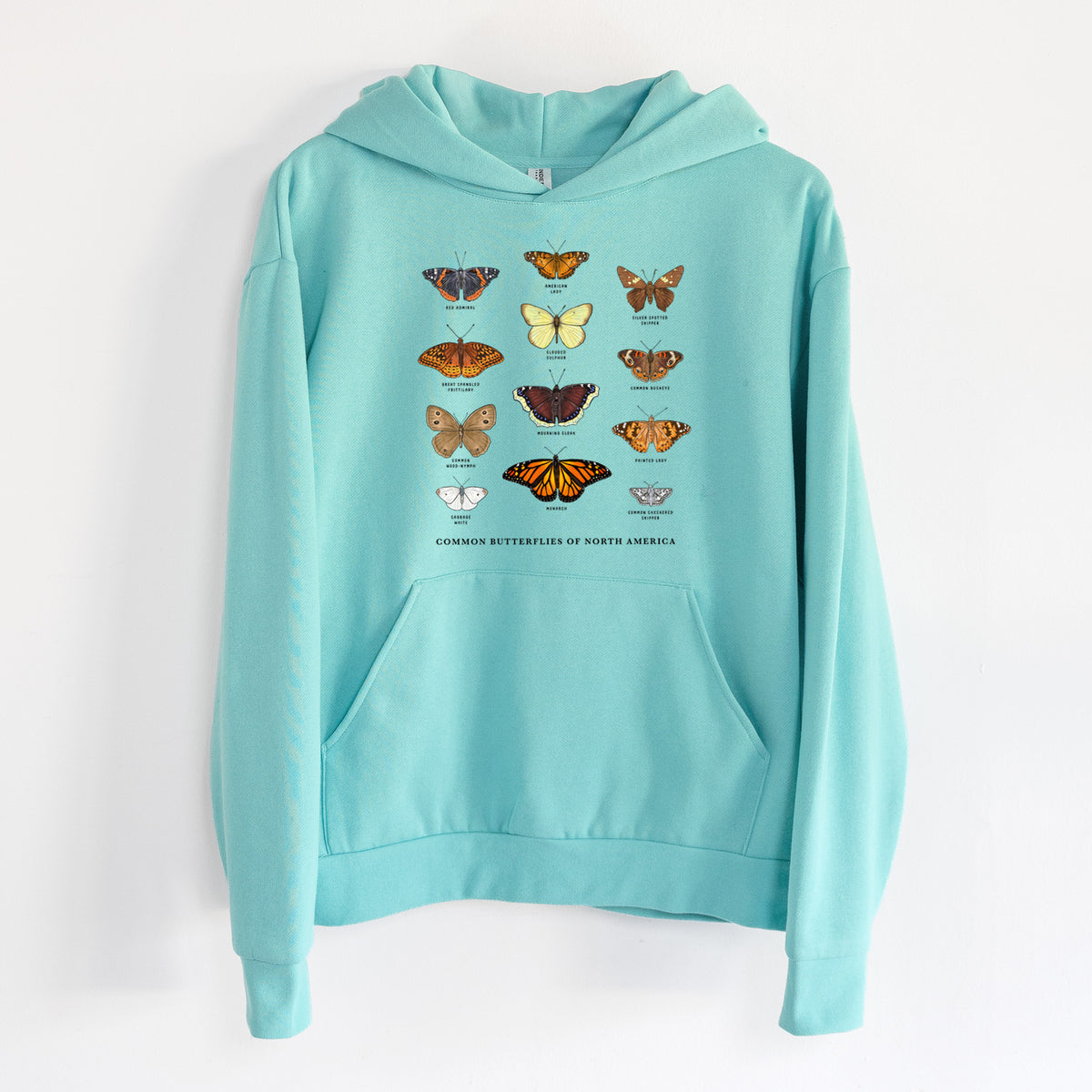 Common Butterflies of North America - Statement Midweight Hoodie in Seafoam, hanging on a white wall, with a front kangaroo pocket and no drawcords.