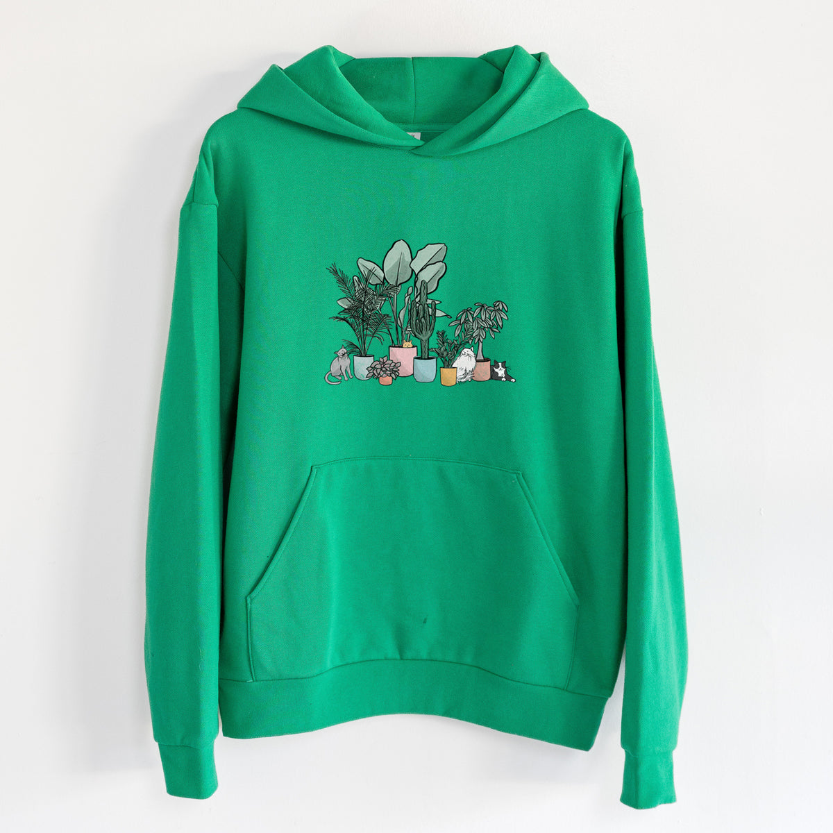 Cats and Plants - Statement Midweight Hoodie in Kelly Green, hanging on a white wall, with a front kangaroo pocket and no drawcords.