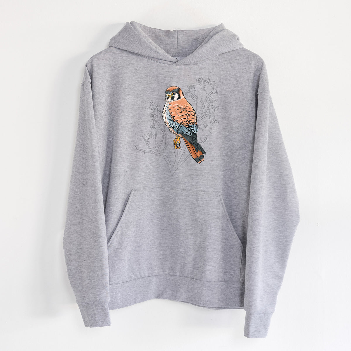 Vibrant American Kestrel - Falco sparverius - Statement Midweight Hoodie in Heather Grey, hanging on a white wall, with a front kangaroo pocket and no drawcords.