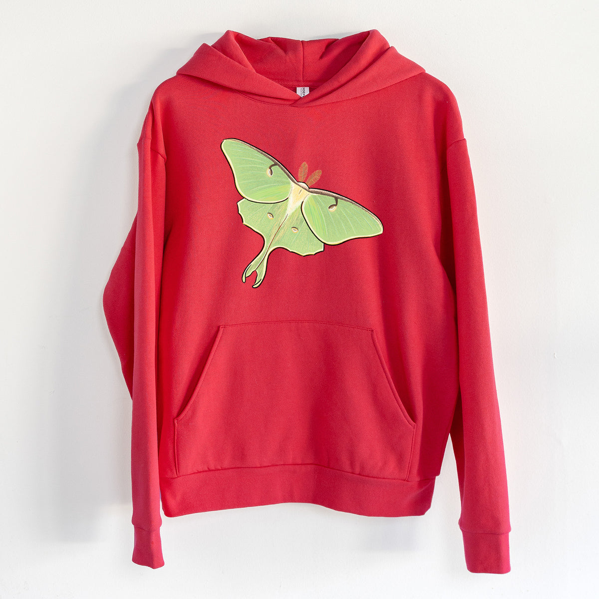 Vibrant Luna Moth - Actias luna - Statement Midweight Hoodie in Cherry Red, hanging on a white wall, with a front kangaroo pocket and no drawcords.
