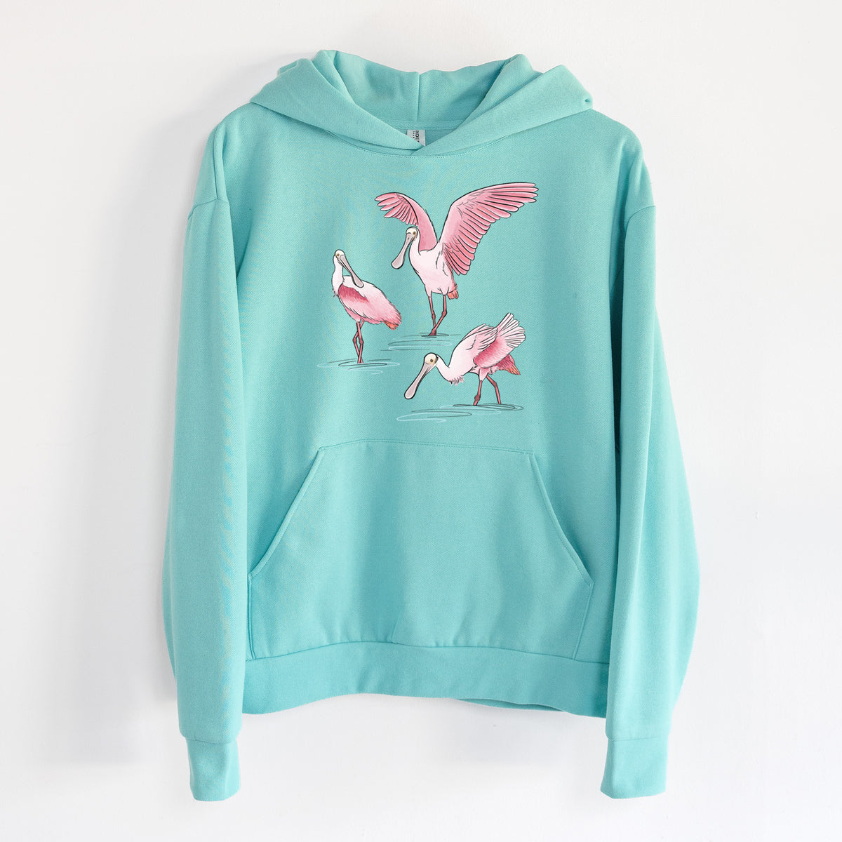 Roseate Spoonbill Trio - Platalea ajaja - Statement Midweight Hoodie in Seafoam, hanging on a white wall, with a front kangaroo pocket and no drawcords.