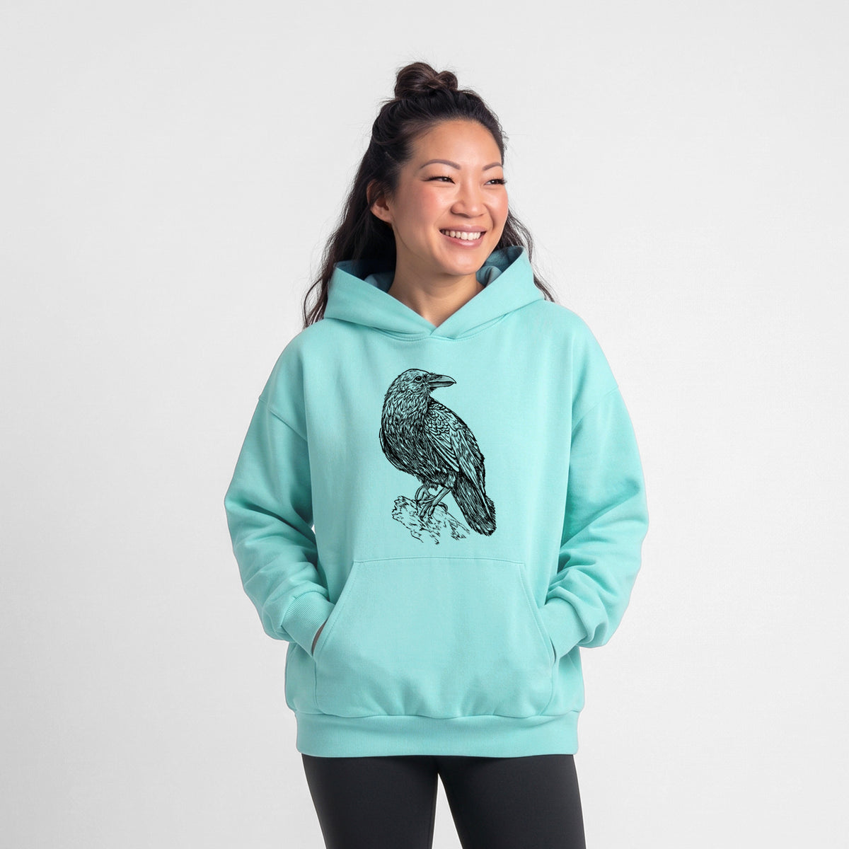 Female model wearing the Corvus corax - Common Raven - Statement Midweight Hoodie.