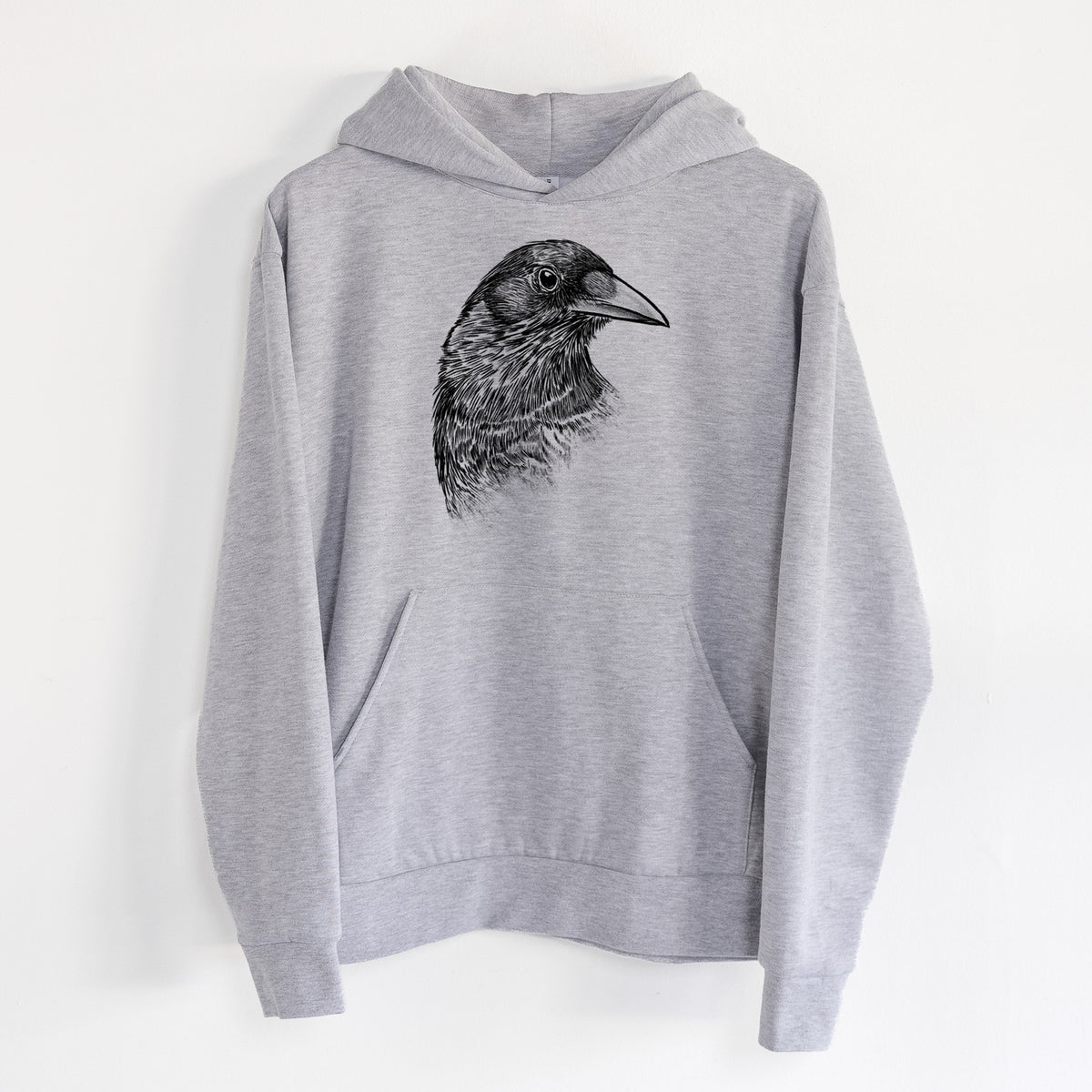 American Crow Bust - Corvus brachyrhynchos - Statement Midweight Hoodie in Heather Grey, hanging on a white wall, with a front kangaroo pocket and no drawcords.