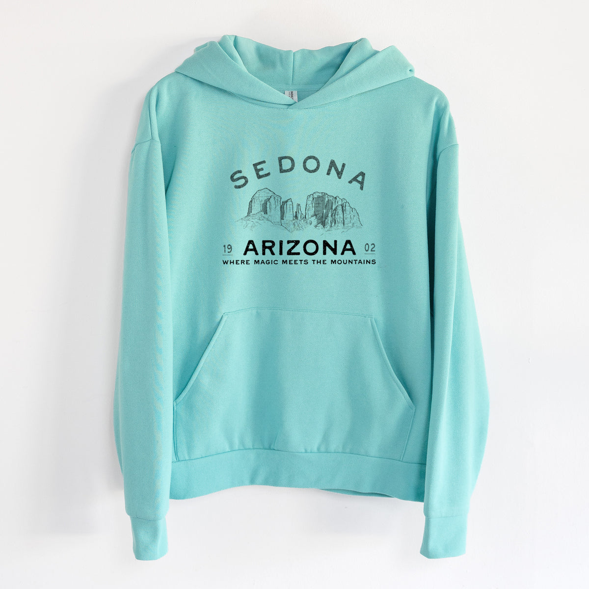 Sedona Arizona Cathedral Rock - Statement Midweight Hoodie in Seafoam, hanging on a white wall, with a front kangaroo pocket and no drawcords.