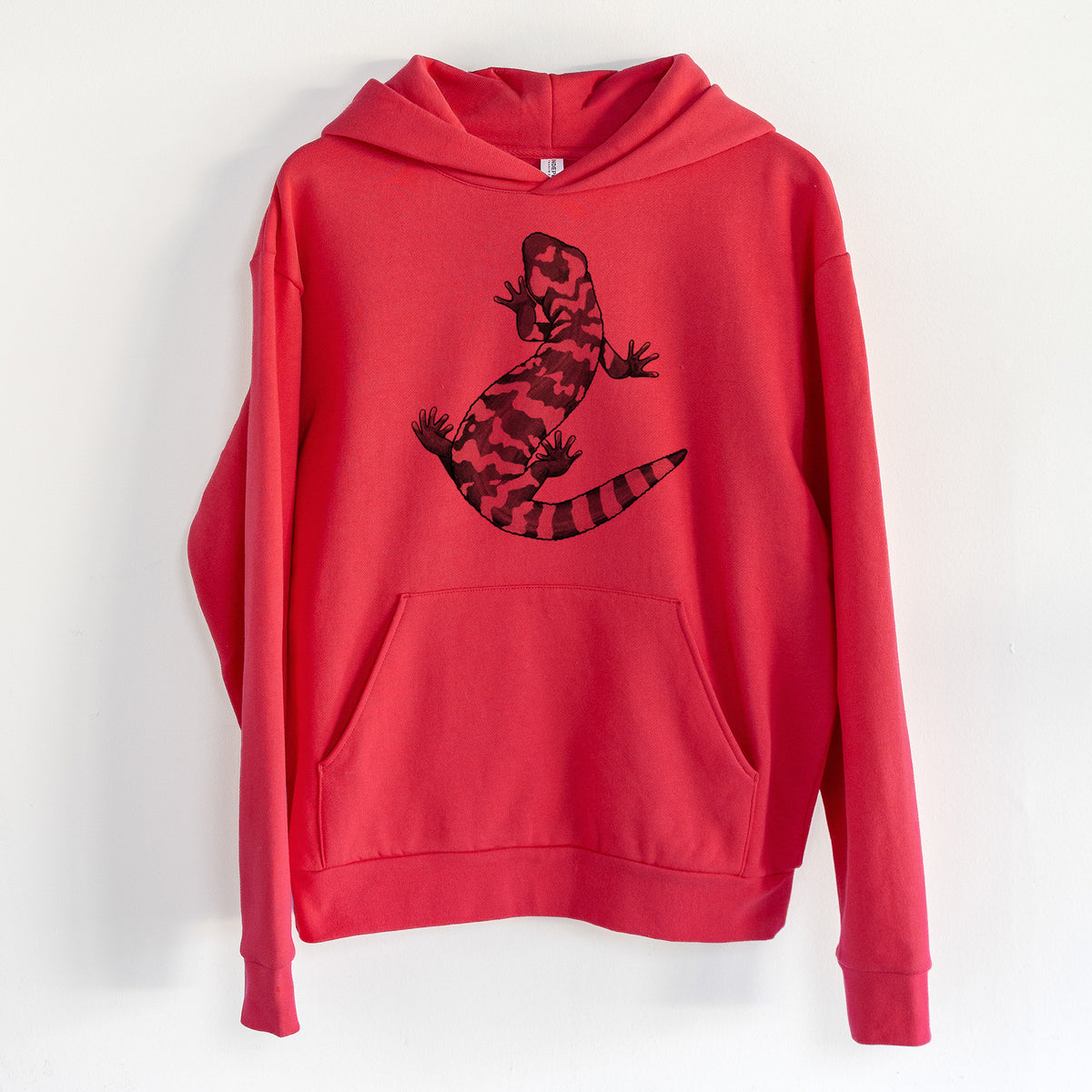 Gila Monster - Heloderma suspectum - Statement Midweight Hoodie in Cherry Red, hanging on a white wall, with a front kangaroo pocket and no drawcords.
